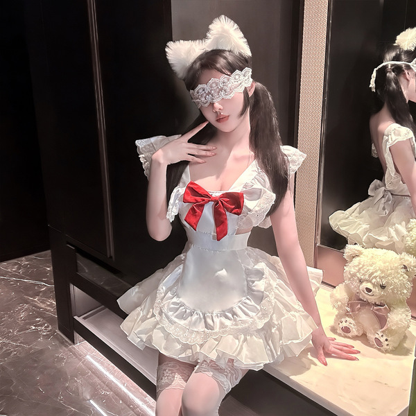 A woman poses in a maid-inspired lolita outfit featuring a white dress with lace details, a red bow, and cat ears. she wears ...