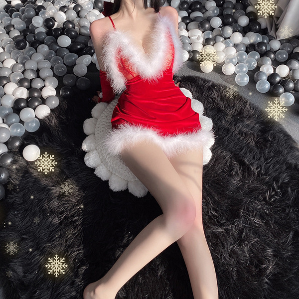 A woman poses in a festive christmas-themed outfit, featuring a red mini skirt with white fur trim and matching lace lingerie...