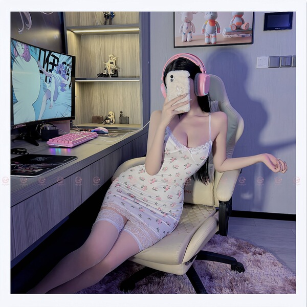 A woman lounges in a gaming chair wearing a floral lace contrast low-cut sexy slip dress, paired with pink headphones, set ag...