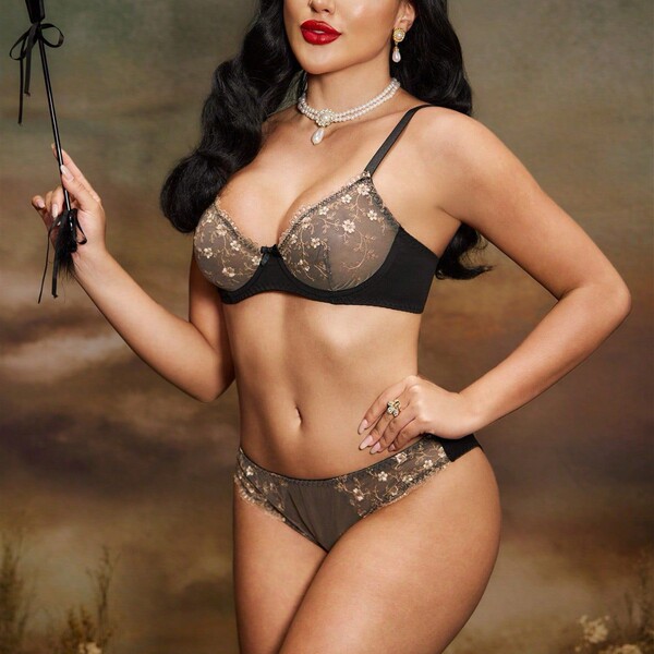 Woman modeling french-style sheer lace lingerie set with floral embroidery, ultra-thin sensual two-piece erotic underwear.