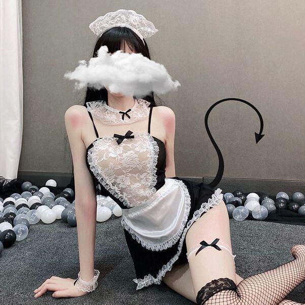 Woman in black and white sexy maid costume with lace apron, headband, and fishnet stockings for erotic role play.