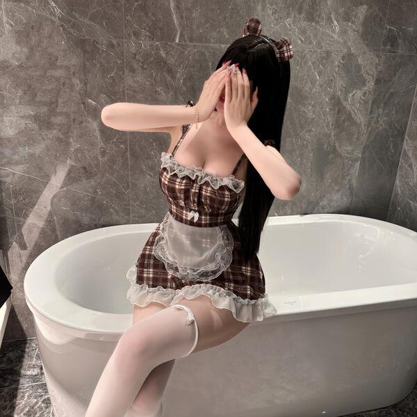 Woman in bird moonling lingerie set, a seductive maid costume with plaid dress and white apron, posing by bathtub.