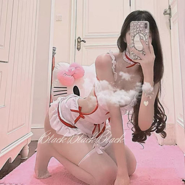 Woman in plus size maid costume taking mirror selfie with hello kitty pillow, featuring white dress with red accents and fril...