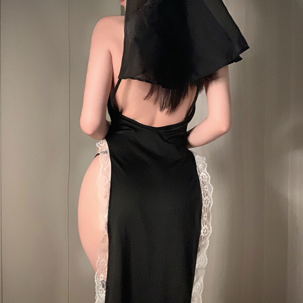 Woman wearing black plus size nun costume with high slit and lace trim, back view showing open design for adult role play.
