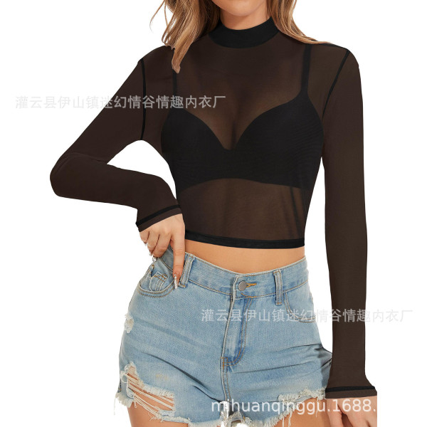 Woman wearing a black sheer mesh long sleeve crop top with high neck, paired with denim shorts.