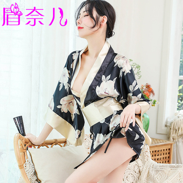 A woman wearing a black floral print robe with gold trim, featuring a tied waist design, ideal for romantic evening wear.