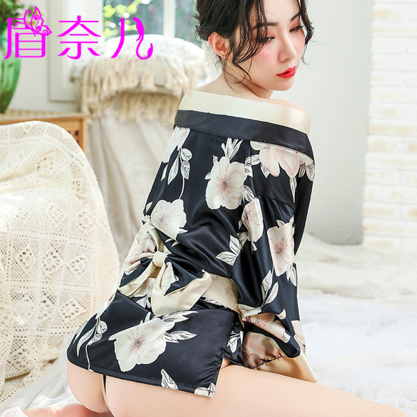 A woman wearing a black floral print robe with off-the-shoulder design, tied waist, and lace details, suitable for romantic l...