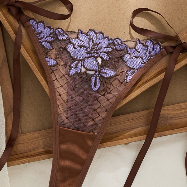 Luxury sheer lace thong with purple floral embroidery and satin ribbons, part of the 2026 pure-temptation lingerie set.