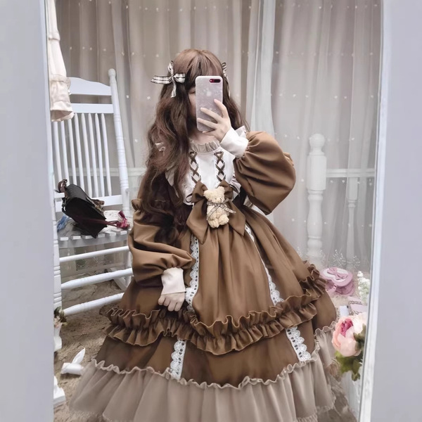 A woman poses in a charming lolita dress featuring long sleeves, ruffles, and lace details, perfect for parties or performanc...