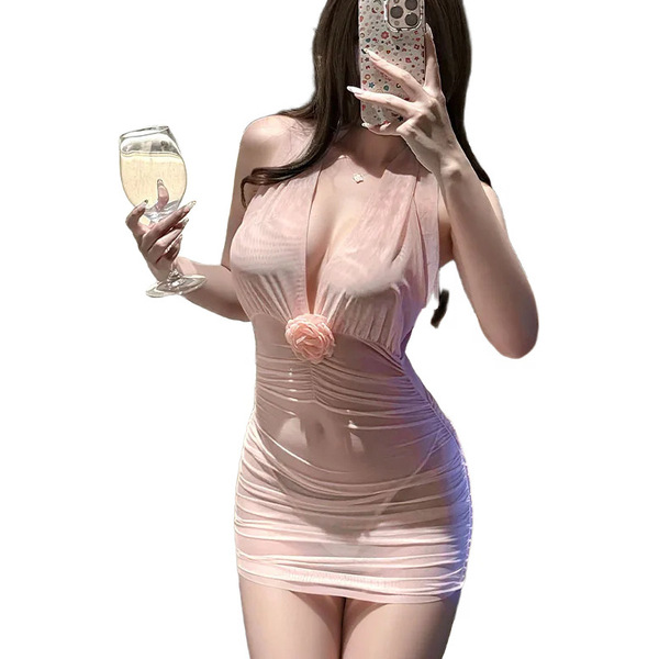 A woman poses in a luxurious pink halter bodycon dress featuring a high slit and tight fit, holding a glass of champagne whil...