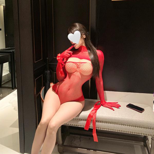 Woman wearing red sheer lace bodysuit with open-crotch mesh design, long gloves, and ribbon accents—sensual lingerie for curv...