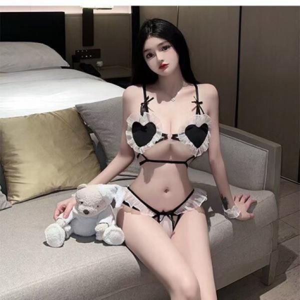 Woman in sexy maid costume with heart-shaped lingerie, sitting on couch with teddy bear. cute & seductive three-piece role pl...
