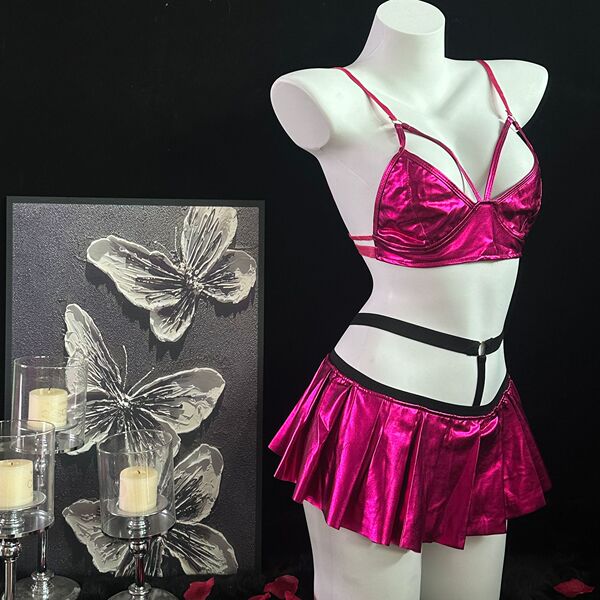 Shiny pink lingerie set with bra, pleated skirt, and black harness on mannequin.