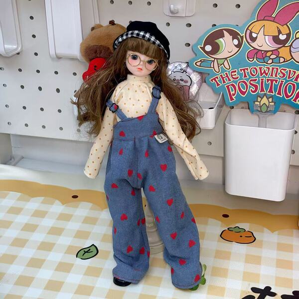 A cute 30cm bjd doll dressed in a polka dot shirt and heart-patterned overalls, standing next to a the townsville position si...