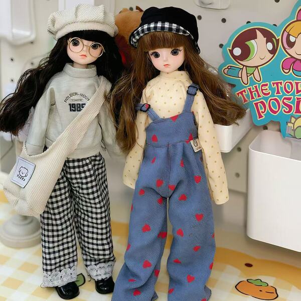Two adorable 30cm bjd dolls dressed in stylish outfits stand side by side, featuring chic hats and playful dresses, perfect f...