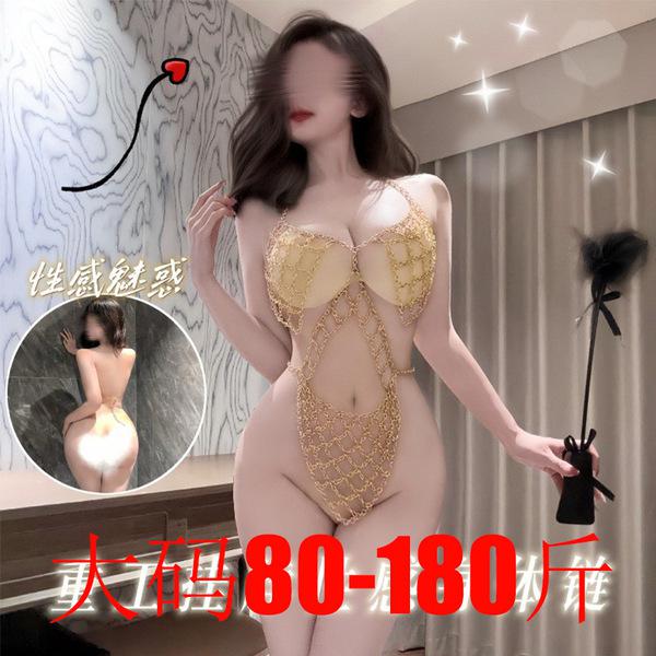 Woman modeling gold lace lingerie set with chains, holding feather wand. see-through erotic outfit for passionate nights.