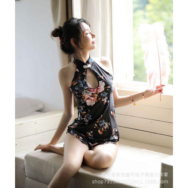 A woman poses elegantly in a black floral printed cheongsam lingerie, featuring a halter neck design and feather accessory, e...
