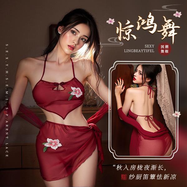 A woman models a red halter bodysuit set with floral embroidery, designed for sensual allure and dance inspiration.