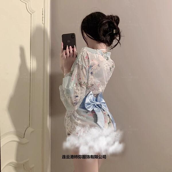 A woman models a delicate, floral-patterned kimono-style sleepwear set with a soft blue ribbon bow, exuding elegance and allu...