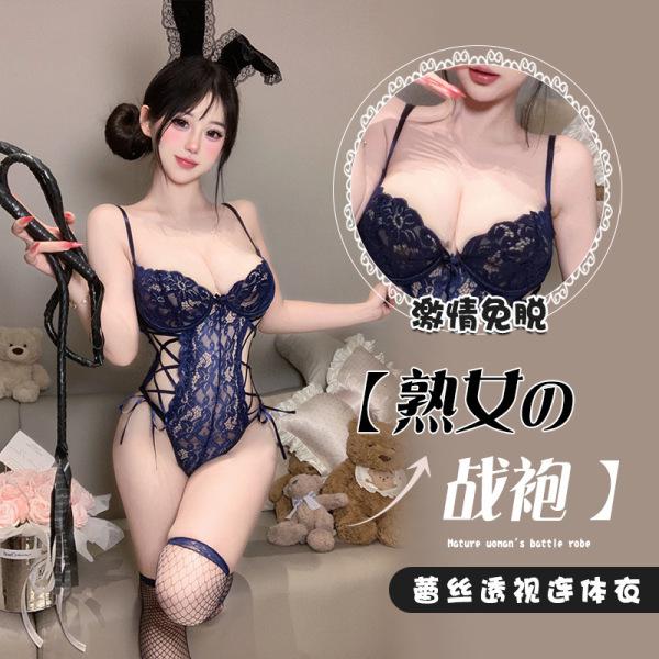 Woman wearing a navy blue lace bunny bodysuit with floral trim and open chest design, holding a whip.