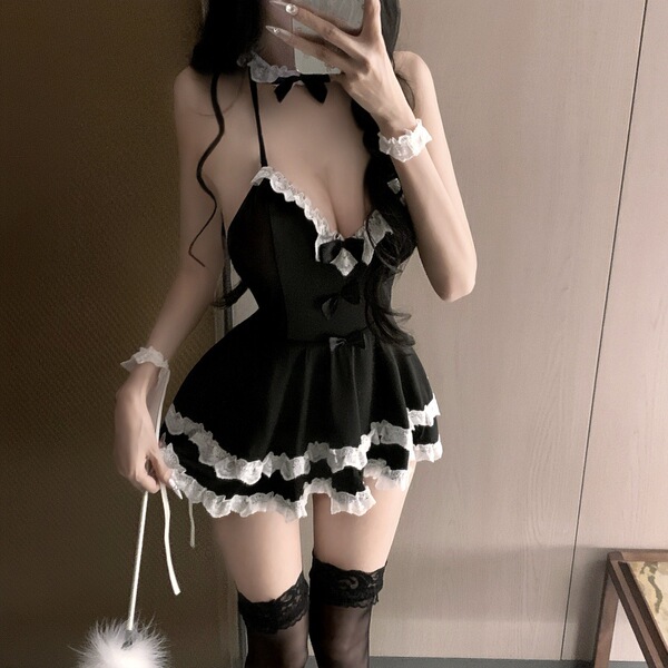 Woman wearing black and white maid costume with lace trim, backless design, bow accents, thigh-high stockings, and feather du...