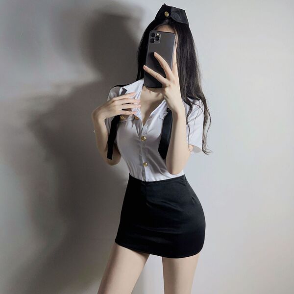 Woman wearing airu airu sexy flight attendant costume with white shirt, black skirt, and hat, posing for a mirror selfie.