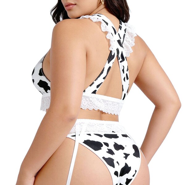 Woman wearing black and white cow print lingerie set with lace trim, featuring a push-up bikini top and matching bottoms.