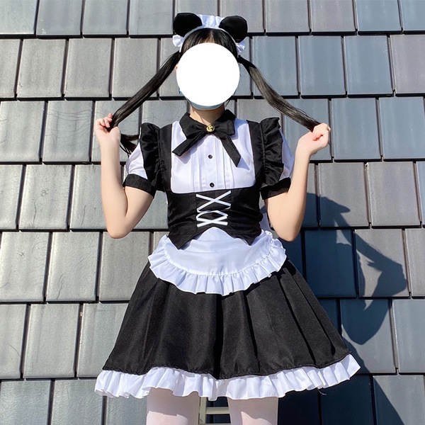 A woman wears a black and white gothic lolita maid dress with pigtails, perfect for halloween costumes.