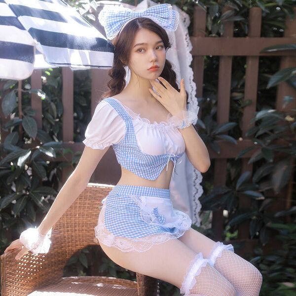 A woman poses in a blue grid maid costume featuring a checkered top, skirt, and stockings, perfect for role play or bedroom f...