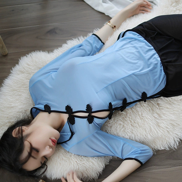 A woman lies on a white rug wearing a blue lace cheongsam lingerie set, featuring sheer silk blend with vintage chinese-inspi...
