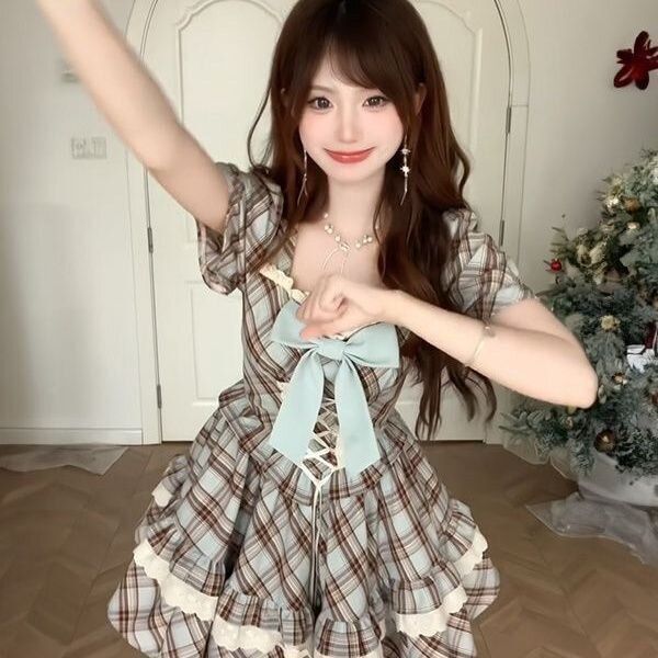 A charming woman poses in a vintage-inspired dress featuring a plaid pattern, lace-up waist, and a-line skirt design, perfect...