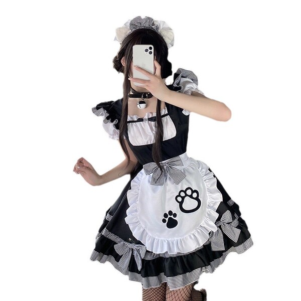 A person wearing a black and white maid costume with cat paw prints on the apron, perfect for cosplay events.