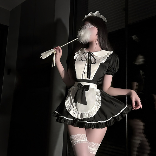 A woman poses in a black and white maid outfit, featuring lace details and a feathered wand accessory, embodying a seductive ...