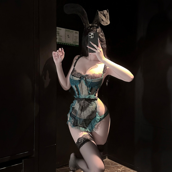 Woman posing in chao mu sensual lingerie set, a sheer polka dot maid outfit with bow and backless design.
