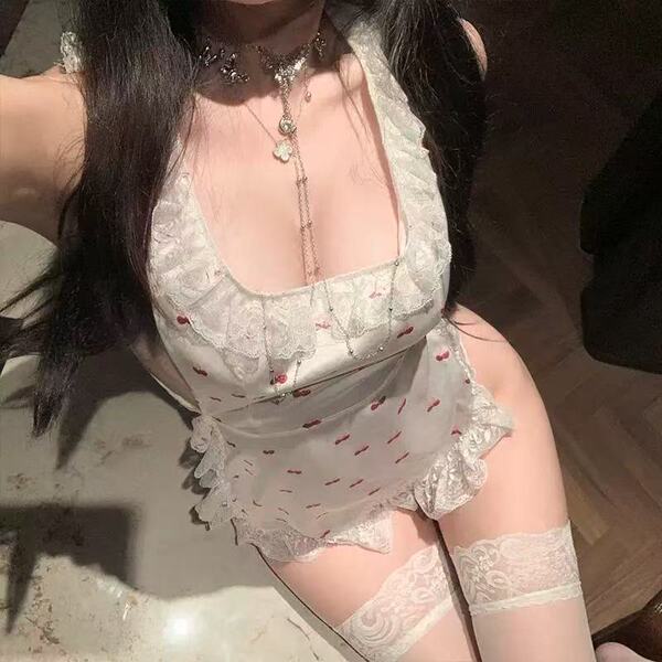 Woman wearing a cherry lace maid costume with a backless apron, cheeky cut-outs, and sheer trim.