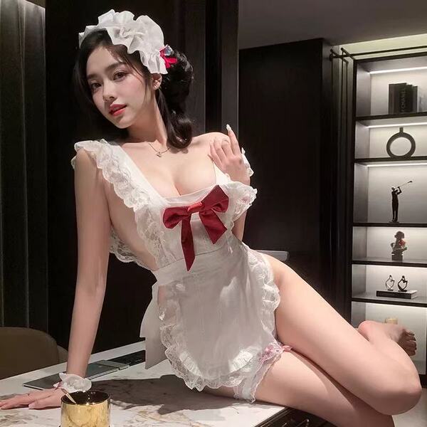 Woman wearing white cherry romance lingerie dress with red bow, lace trim, and maid headpiece in elegant room setting.