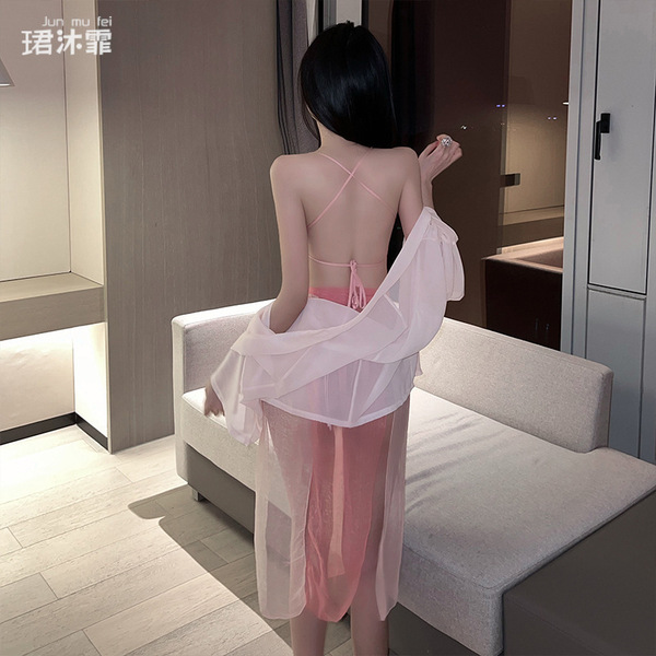 A woman stands facing away from the camera, wearing a delicate pink chinese ancient hanfu lingerie set. the outfit features a...