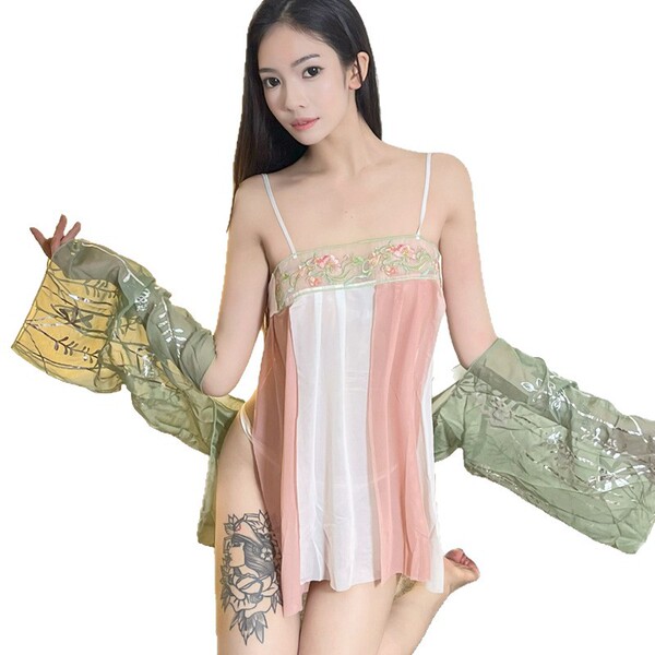 A woman wears a sheer silk qipao sleep dress with floral embroidery, paired with matching sheer sleeves, embodying vintage-in...