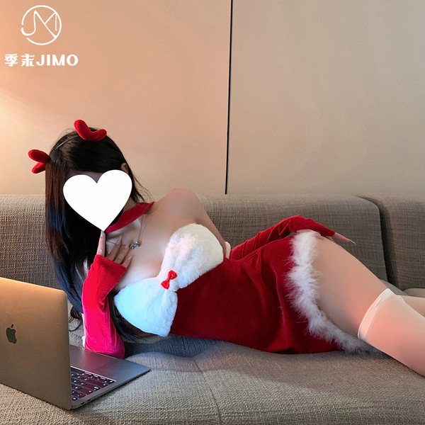 A woman lounges on a couch wearing a festive red christmas bunny girl costume with an asymmetrical corset design, perfect for...
