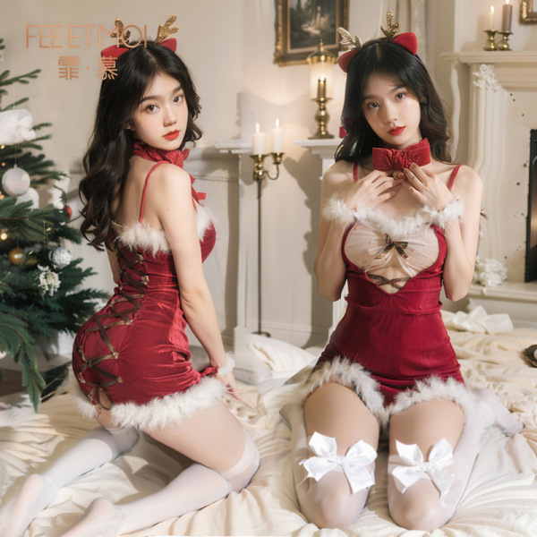 Two women in red christmas-themed fuzzy sheer lace lingerie sets with reindeer antlers, posing on a bed near a decorated tree...
