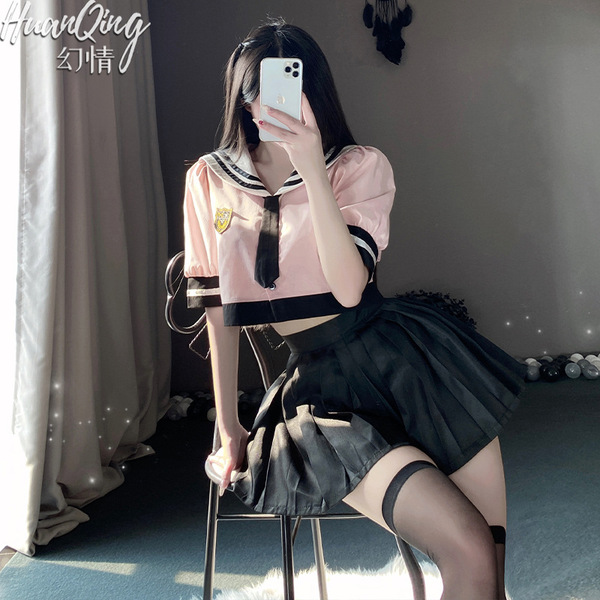 A woman poses in a pink sailor uniform with black pleated skirt, capturing herself in mirror selfie style. perfect for school...
