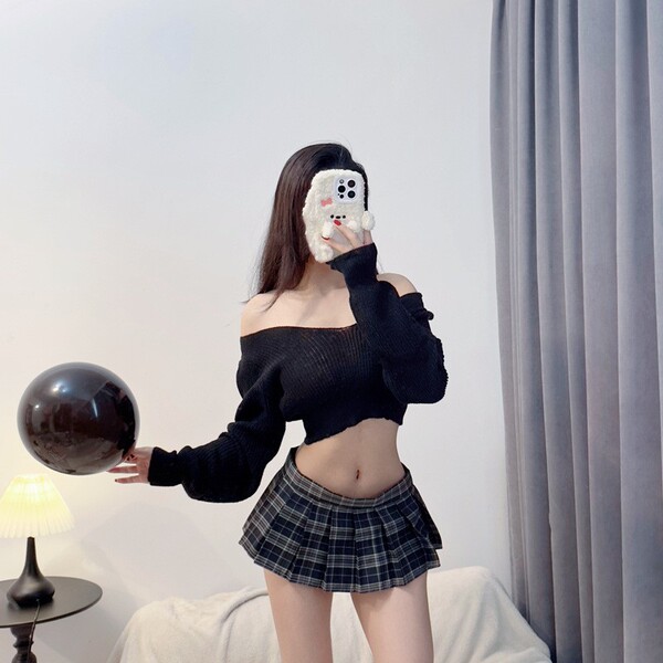 A woman poses with a balloon, wearing a black off-shoulder sweater and a plaid mini skirt, showcasing a cute schoolgirl-inspi...