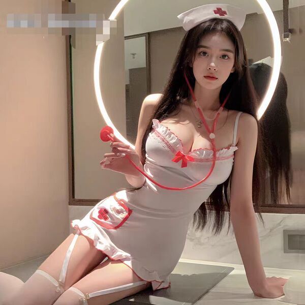 Woman in white nurse-themed lingerie set with red accents, posing seductively on bathroom counter.