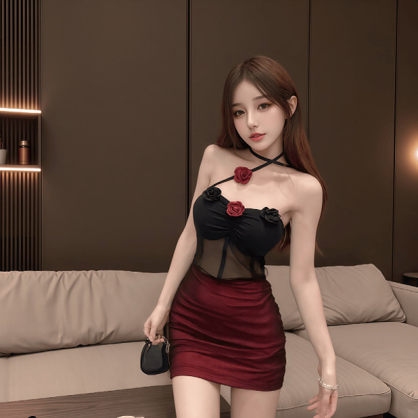 Woman modeling dark romance lace bodysuit with sheer mesh and red rose details, paired with a burgundy skirt.