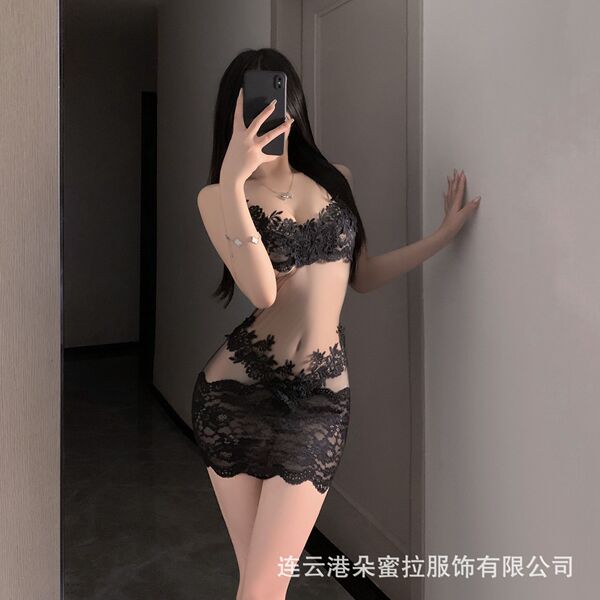 A woman poses in a black lace bodysuit with open design, featuring intricate patterns and a revealing cut. the outfit highlig...