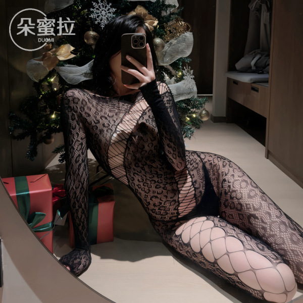 Woman wearing domoila irregular mesh sheer leopard bodysuit with backless lace-up design, posing in front of christmas tree.