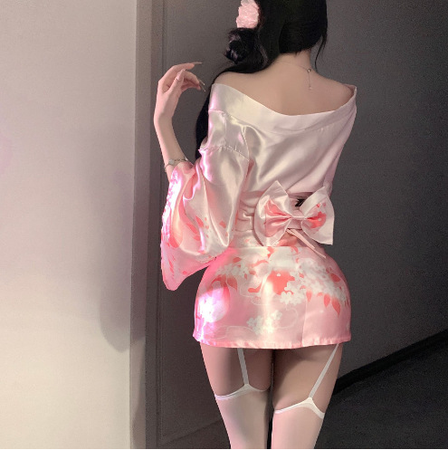 A woman models the domoira temptation lingerie set, featuring a pink floral kimono-style design with a deep v neckline and bo...
