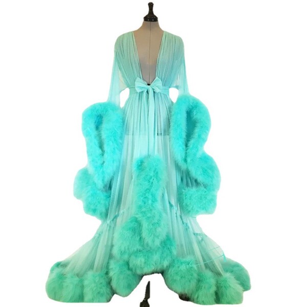 Elegant feather sleeve gown with sheer fabric and dramatic train, featuring luxurious rabbit fur accents for a luxurious look...