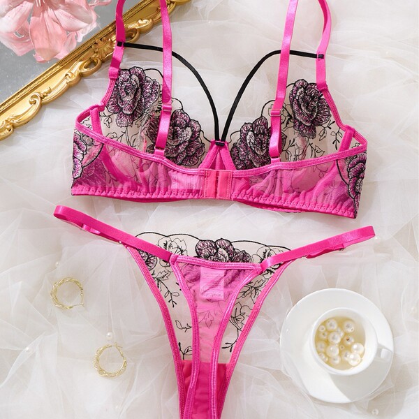 Sheer lace lingerie set with floral embroidery, featuring a transparent bra and matching panty in vibrant pink.
