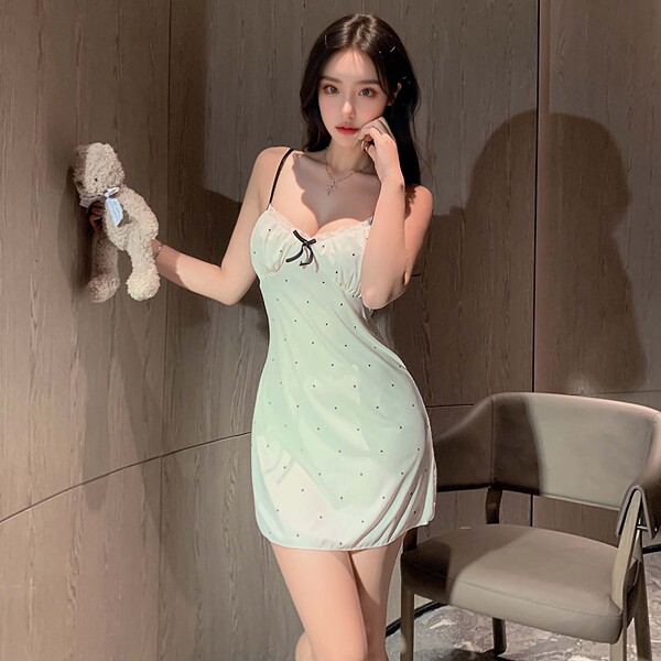 A woman poses with a teddy bear, wearing a light green lace sleepwear set featuring adjustable straps, a bow detail, and remo...